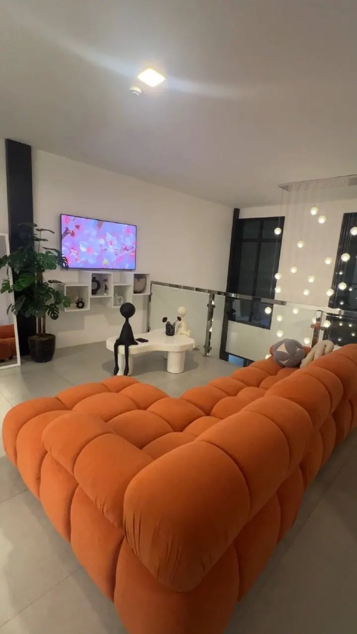 Modern open-plan living room with orange sectional sofa