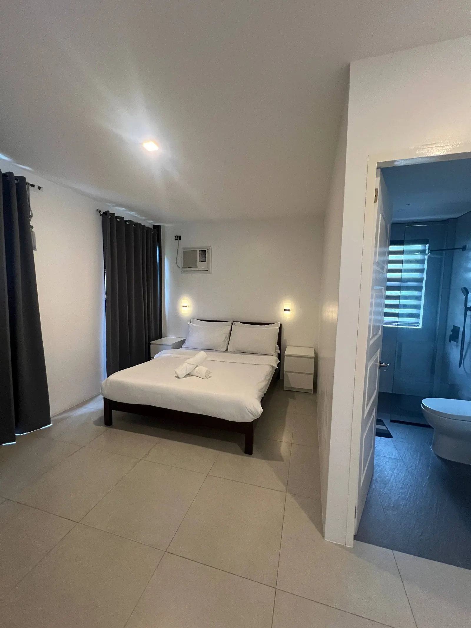 Bedroom 2 with queen bed, white linens and open doorway to en-suite