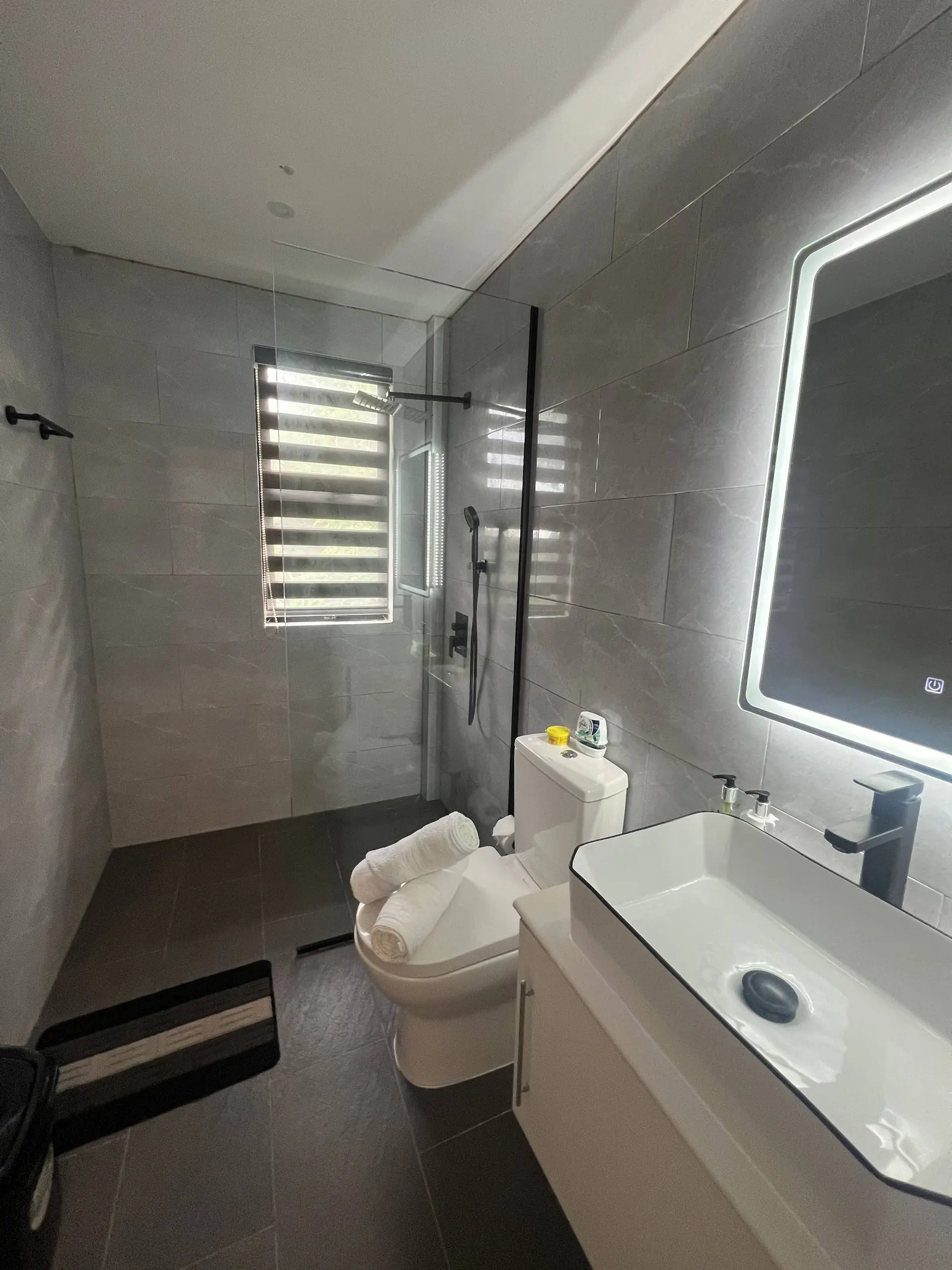 En-suite with glass shower, rainfall head and backlit mirror