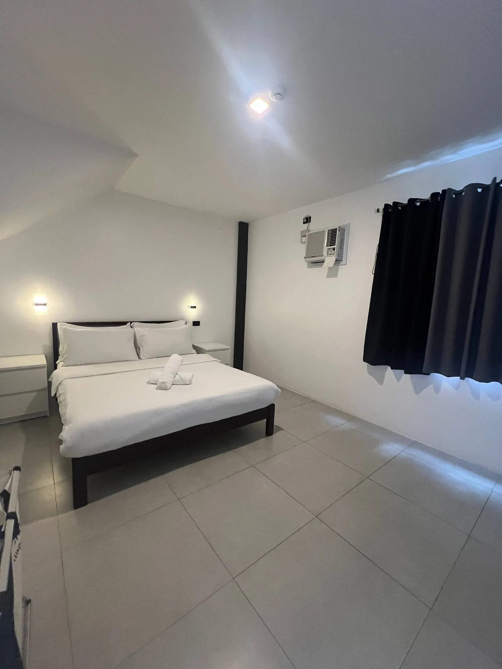 Bedroom 3 with slanted ceiling, queen bed and warm sconces