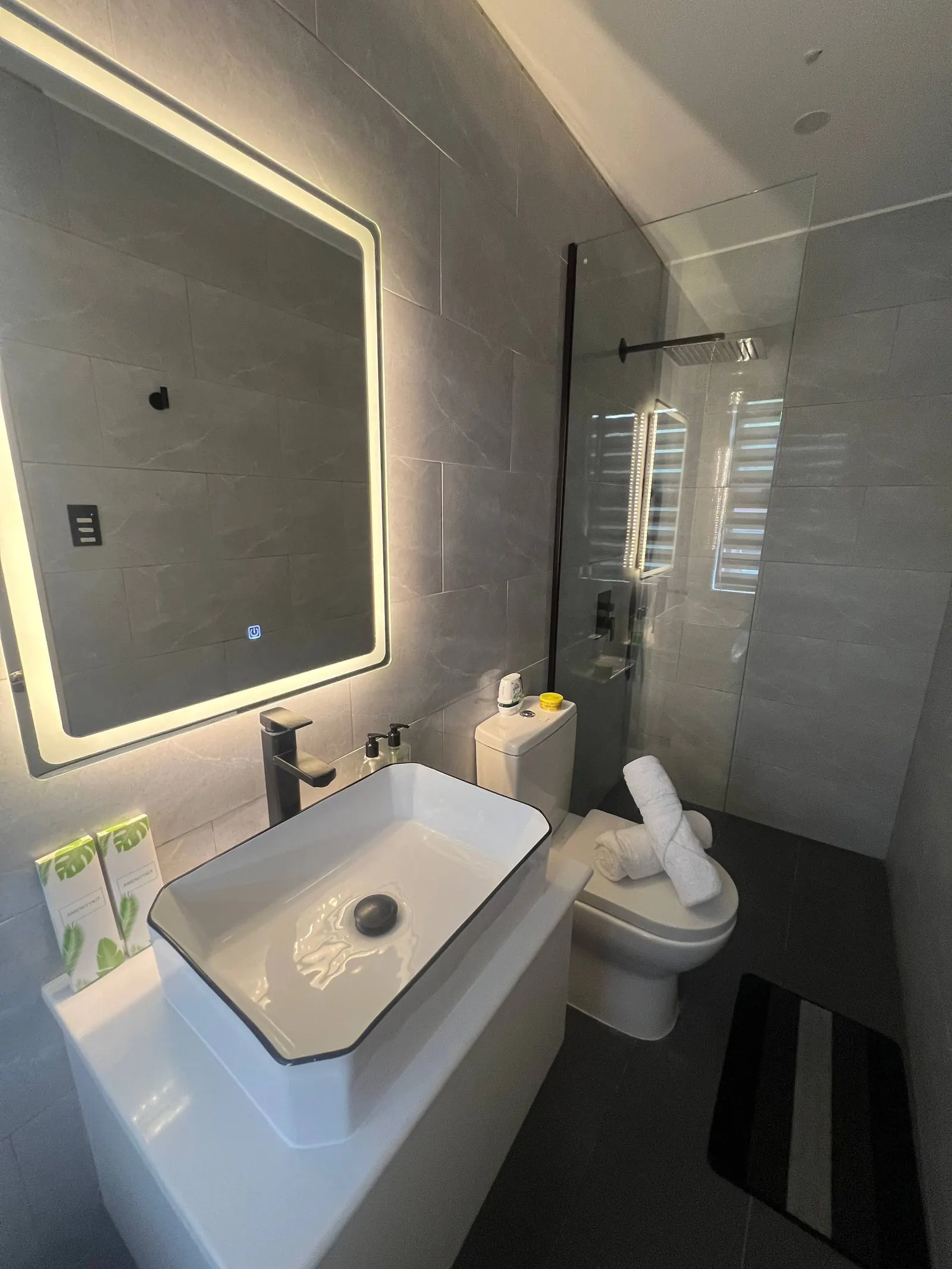 En-suite vanity with LED mirror, vessel sink and black faucet