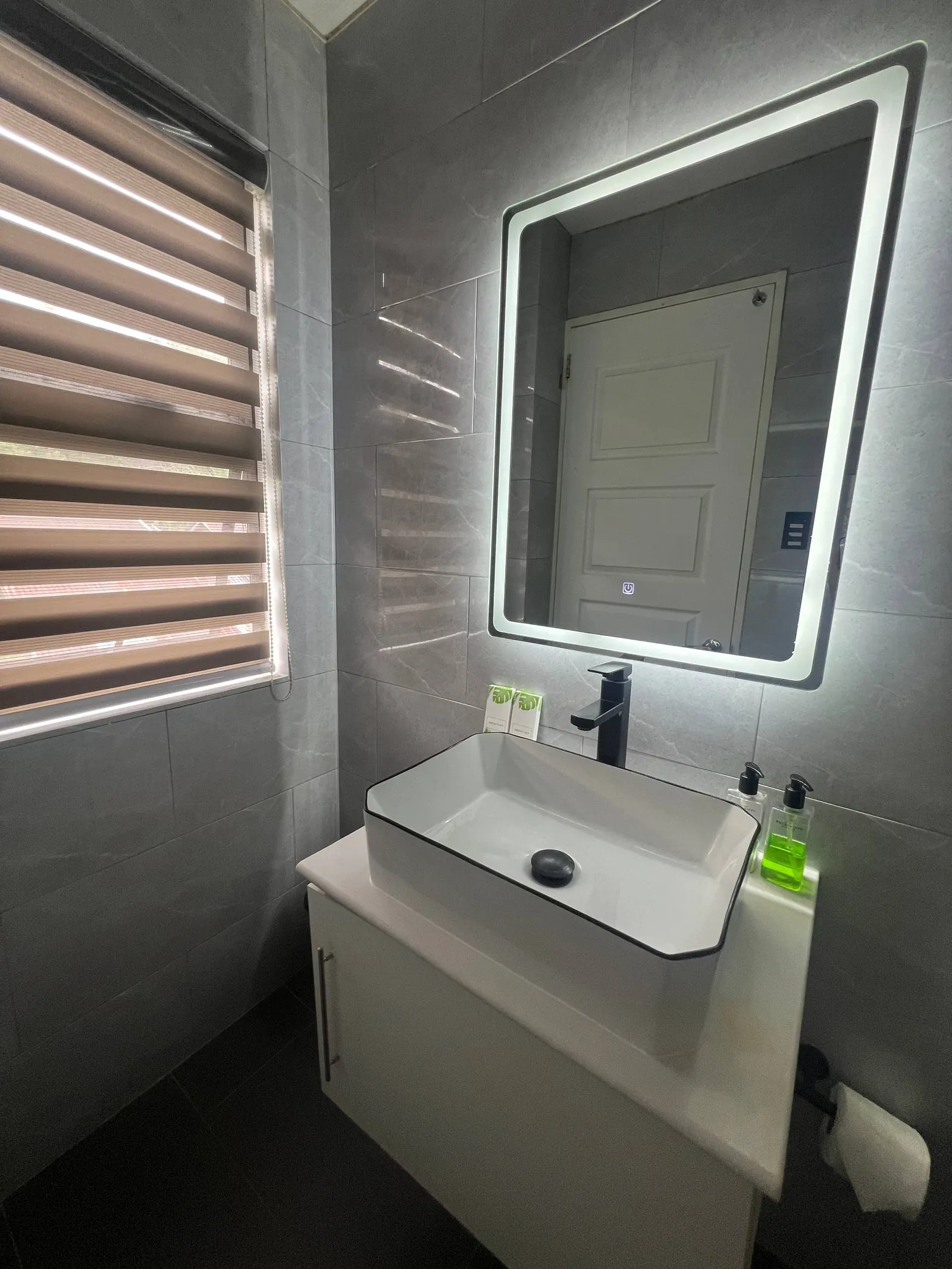 En-suite vanity, mirror and window with natural light
