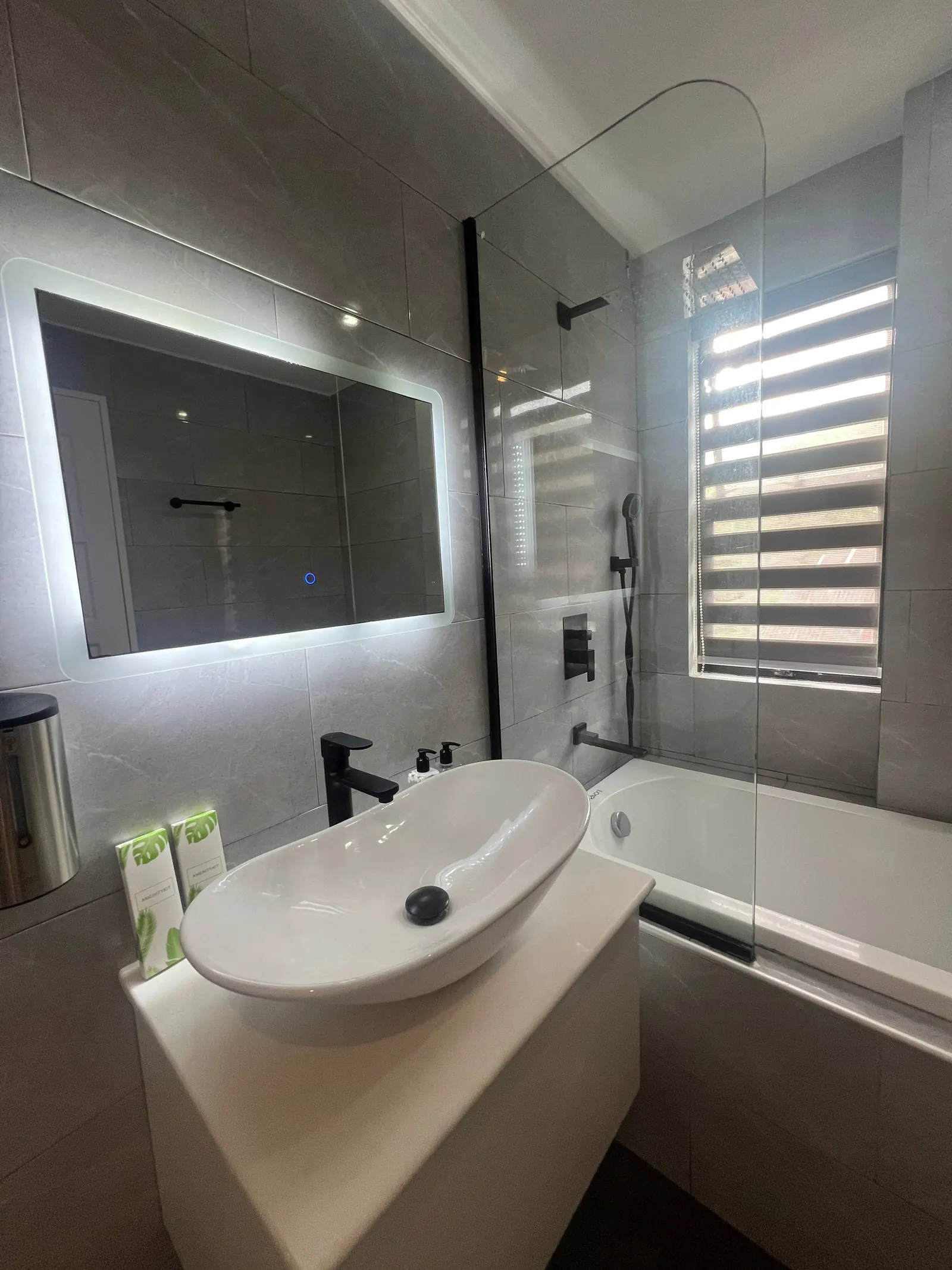 En-suite vanity with vessel sink, LED mirror and black faucet