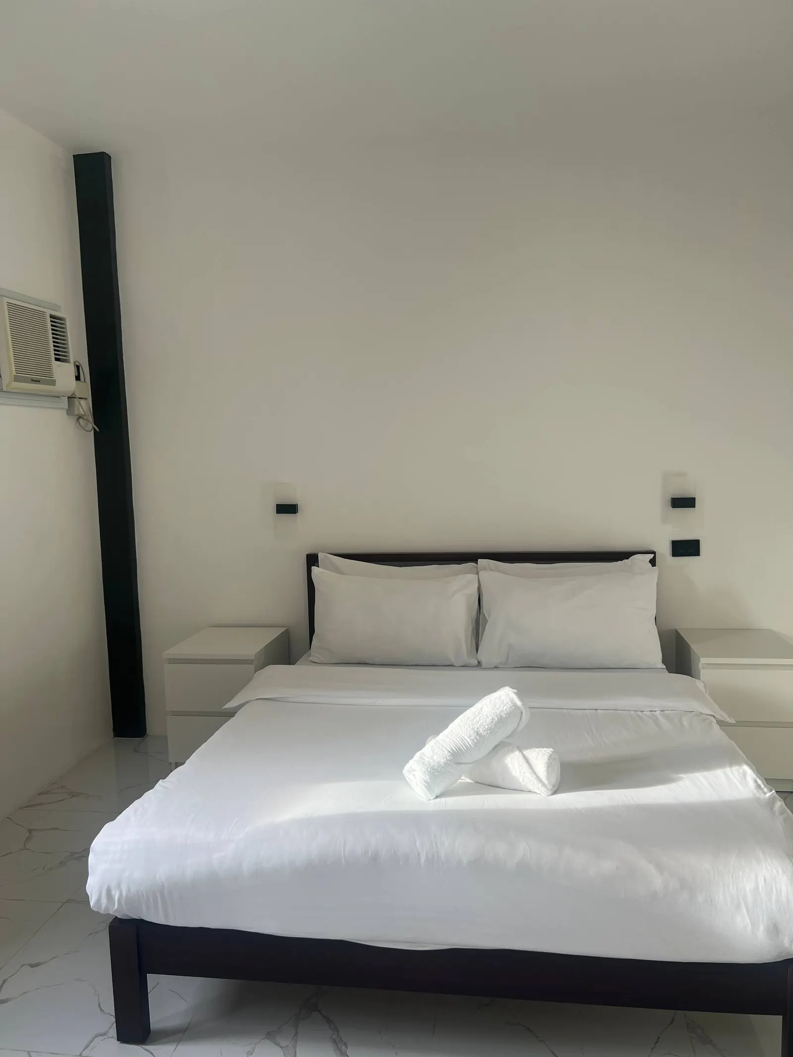 Bedroom 5 ground floor queen bed with dark wood and white linens