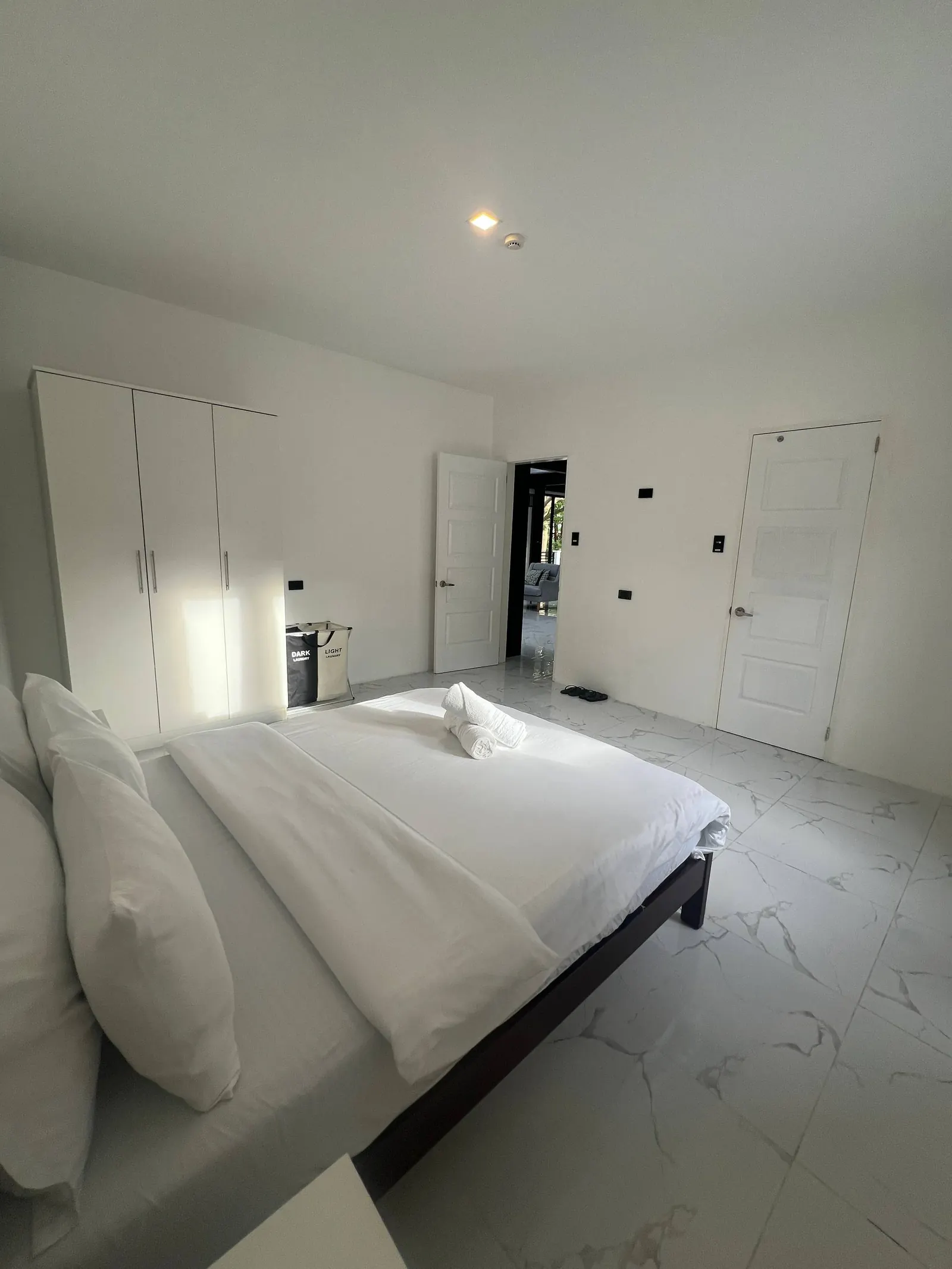 Bedroom 5 from foot of bed with open door to living area