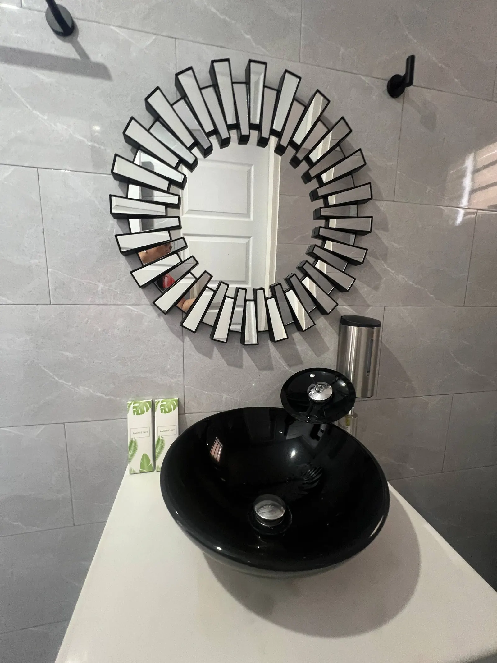 En-suite mirror reflection and black sink details