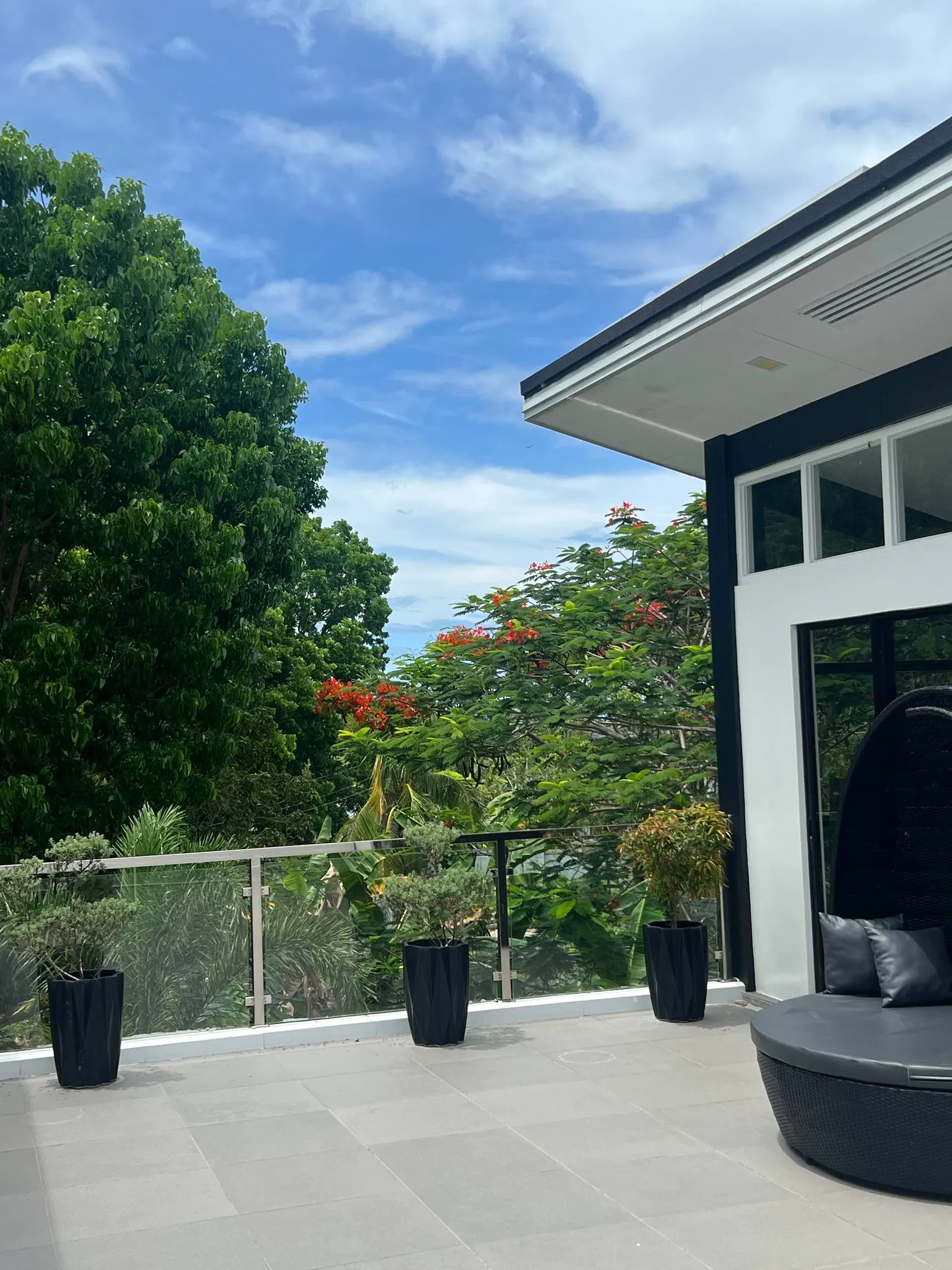 Rooftop outdoor living terrace with daybed and tropical views